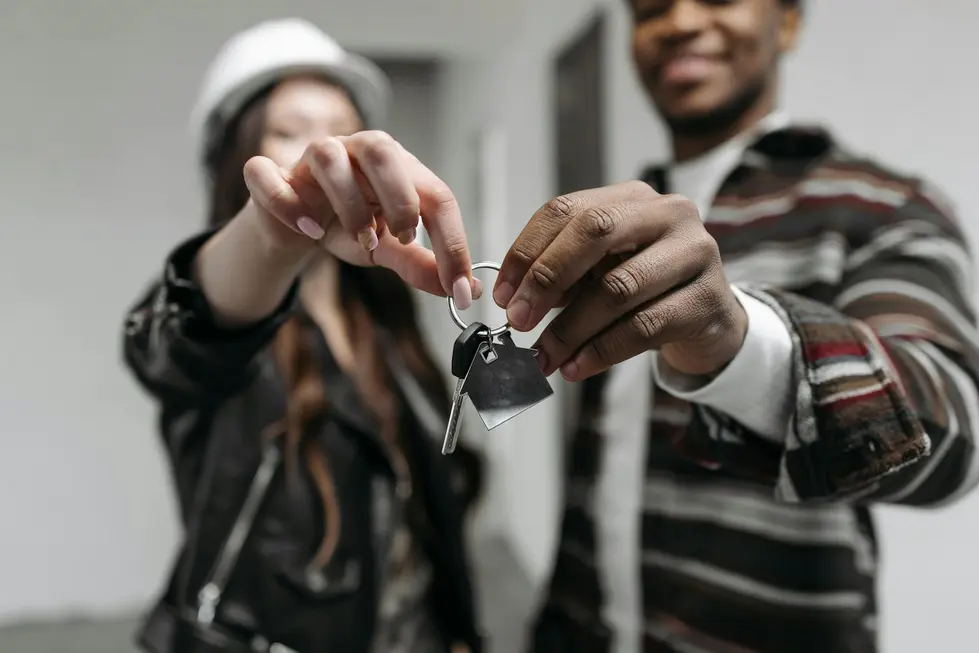 Jovens felizes recebendo chaves da casa após consórcio