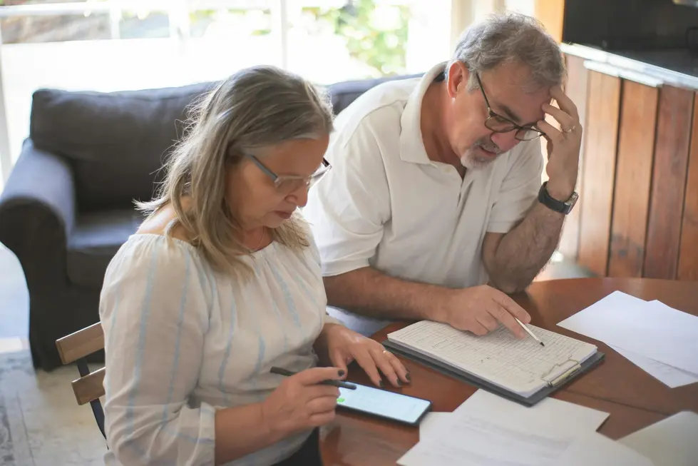 Casal idoso feliz conferindo documentos financeiros em casa