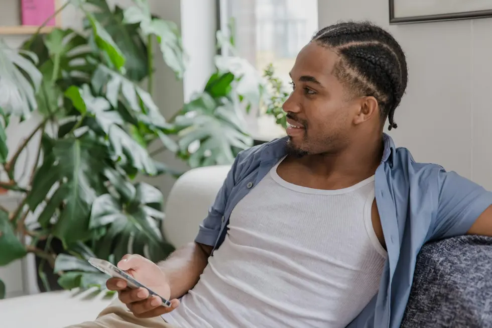 Homem consulta aplicativos financeiros no celular em casa