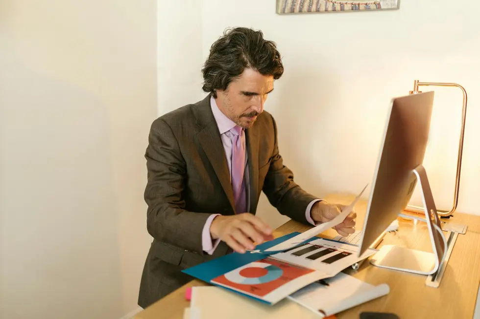 Profissional analisando relatórios empresariais e domésticos lado a lado