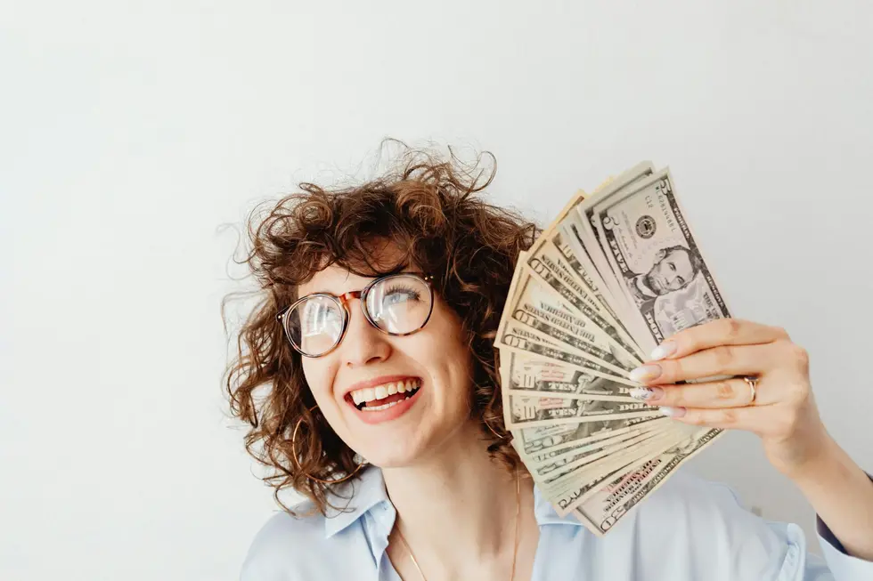 Pessoa feliz ao controlar contas e finanças na própria casa