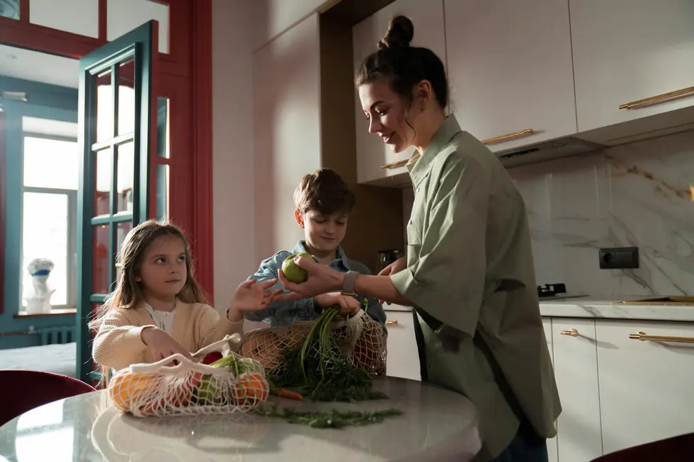 Família posa feliz com compras ecológicas em casa