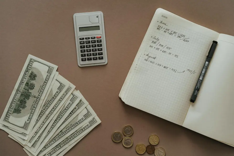 Moeda Ethereum ao lado de notas de real e calculadora sobre mesa