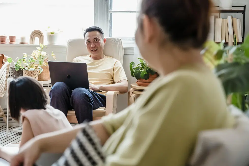 Família brasileira sorrindo com notebook aberto em análise de finanças e Ethereum