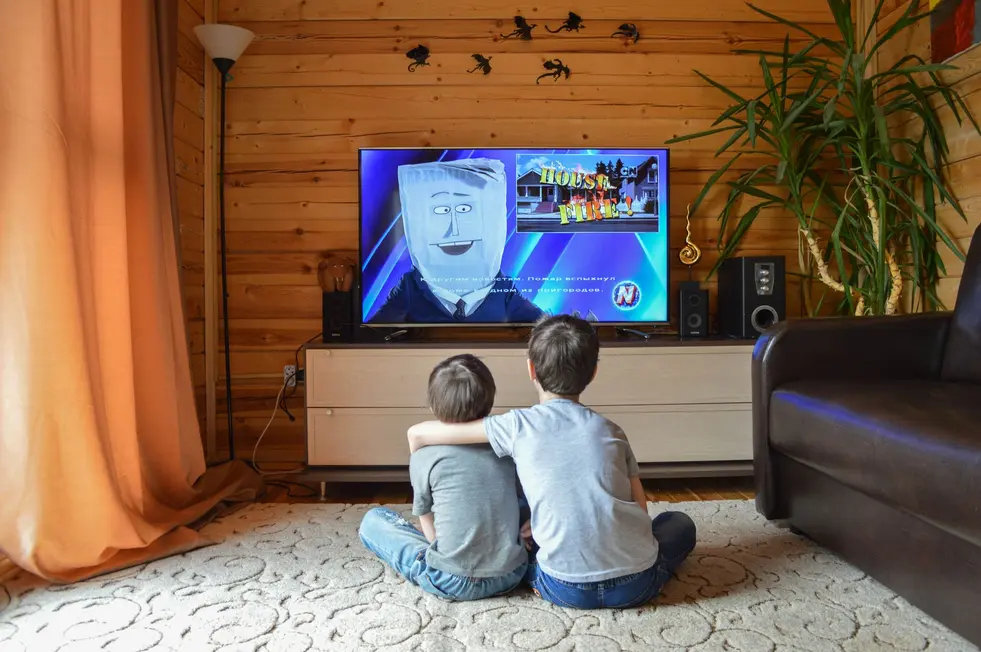 Família feliz assistindo gráfico de Ethereum na TV em casa