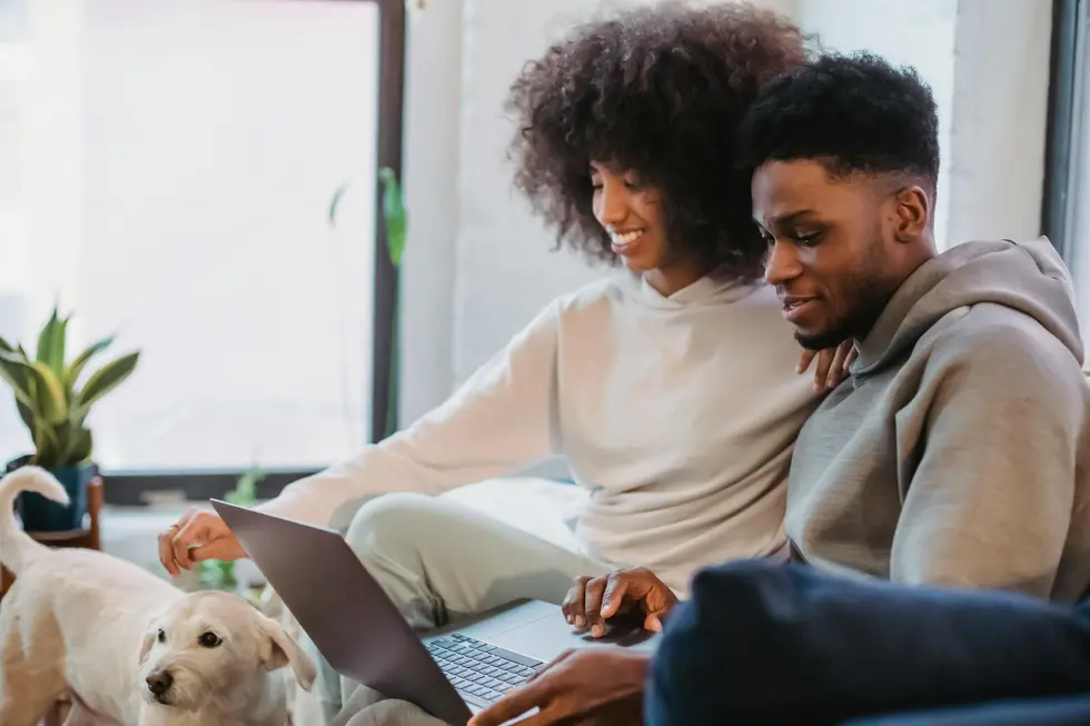Casal olhando tela de laptop com Ethereum e sorrisos de satisfação