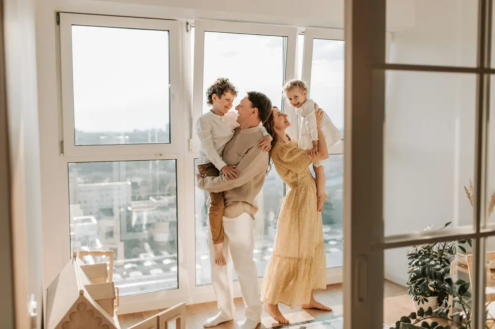Pai, mãe e filhos comemorando juntos dinheiro recebido de seguro no lar
