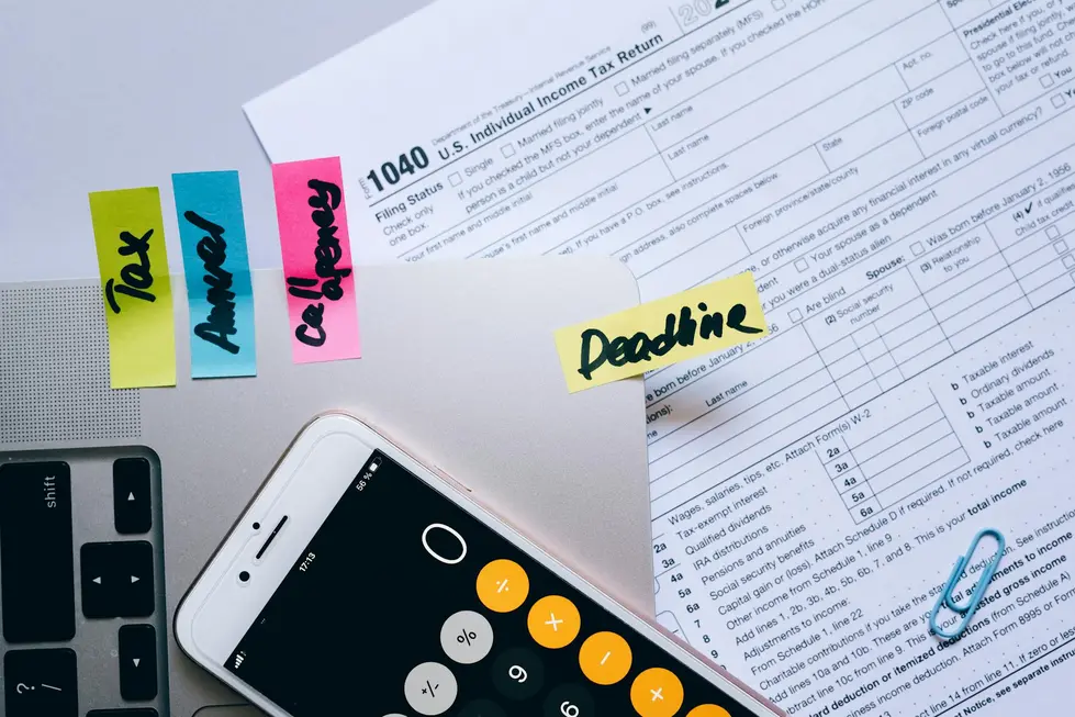 Mesa com celular, papéis e calculadora mostrando orçamento com dados de mercado