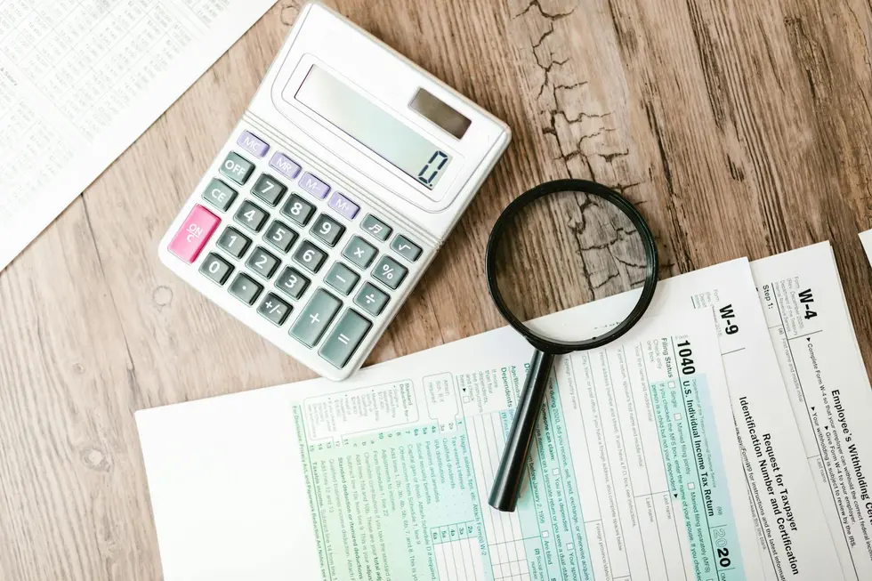 Mesa com documentos organizados, calculadora e formulários do IR