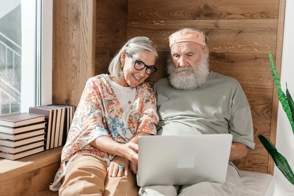 Casal de idosos felizes em casa com documentos financeiros
