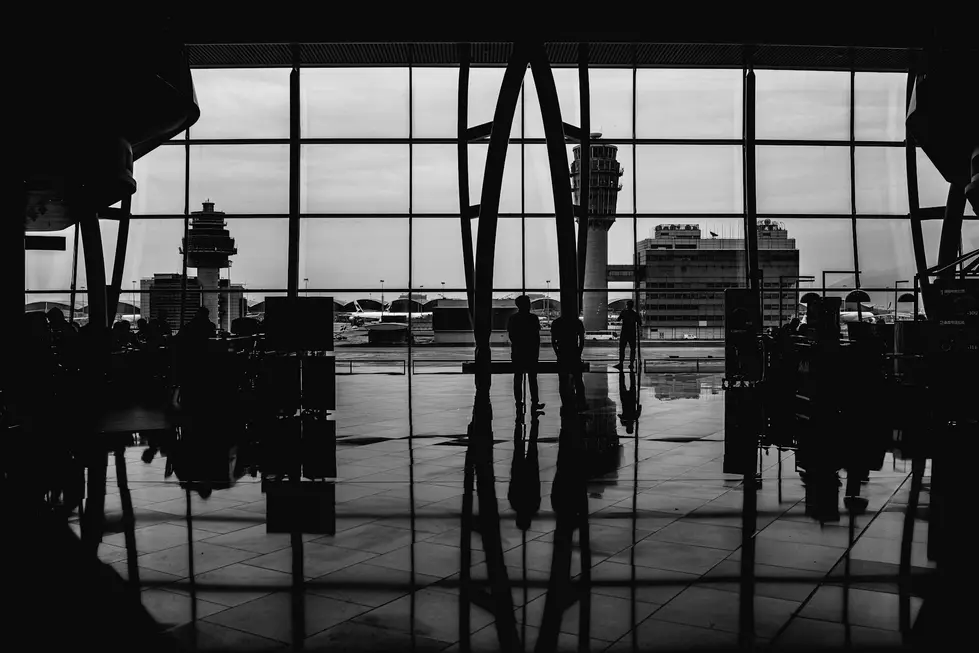 Aeroporto movimentado com passageiros e aviões ao fundo