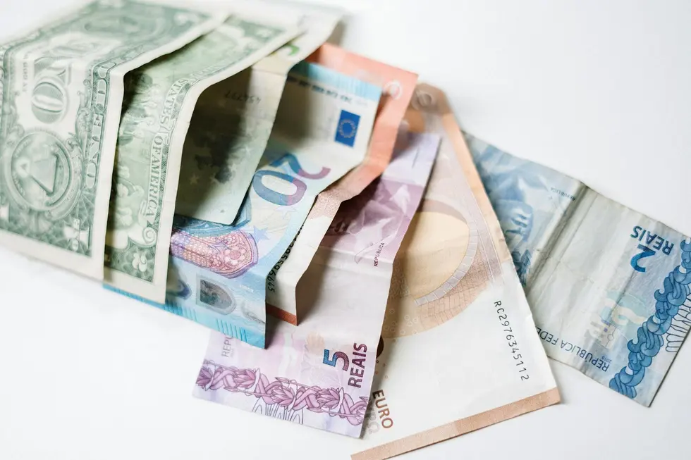 Notas de real e dólar posicionadas lado a lado