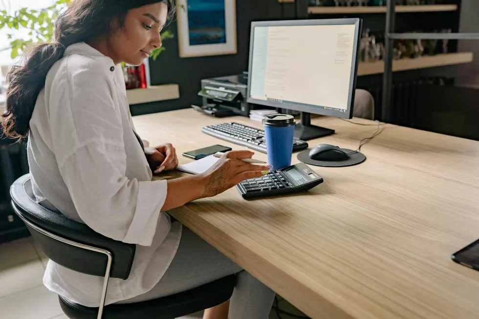Ambiente moderno com computador exibindo taxas do CDI e planilha de investimentos
