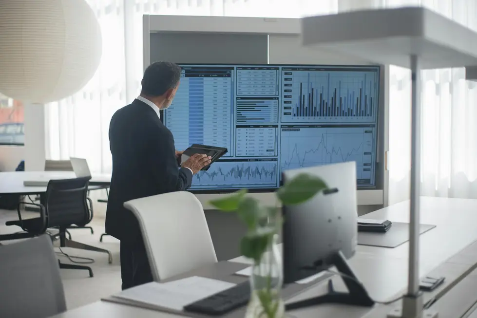 CFO observando dashboards financeiros em escritório moderno