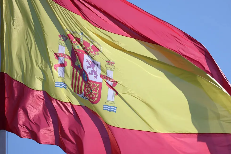 Bandeira da Espanha e mala de viagem ilustrando mudança