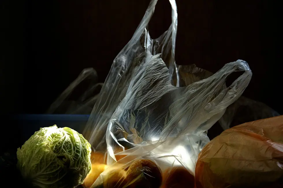 Mesa de cozinha com sacolas de compras, recibos e calculadora