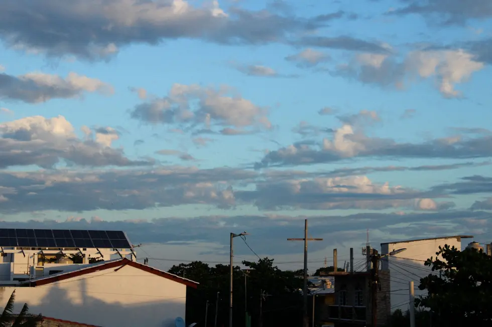 Família em frente a casa moderna com placas solares