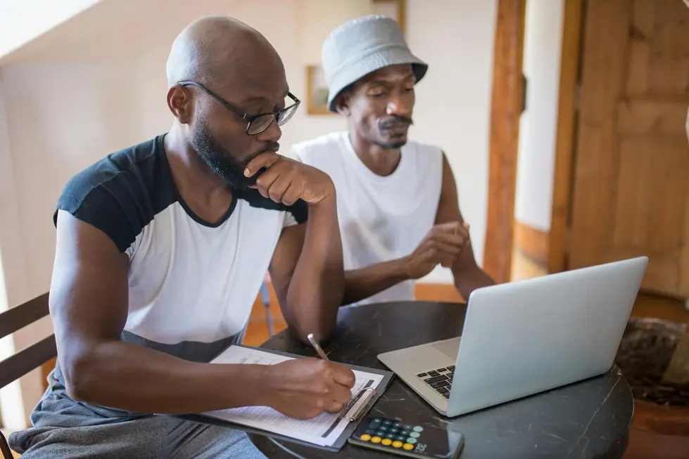Família reunida em volta do laptop analisando dados de mercado em casa