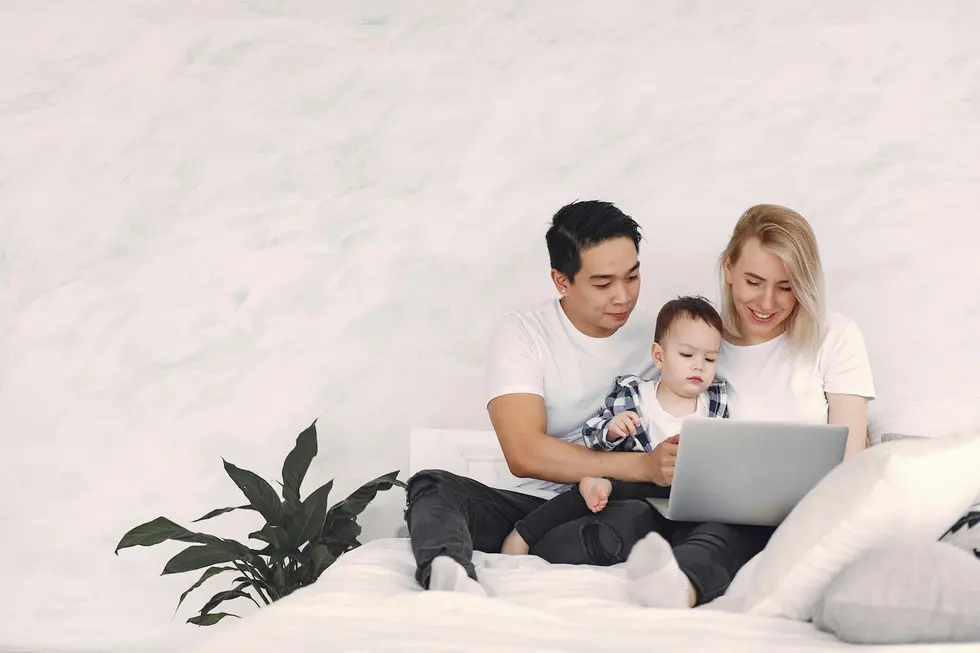 Família feliz conferindo rendimentos de dividendos em laptop