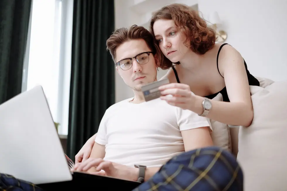 Casal usando notebook com proteção em compras digitais