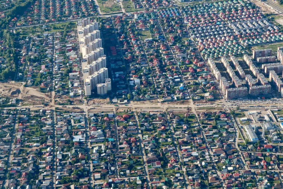 Bairro brasileiro com casas modernas e famílias aproveitando o espaço externo