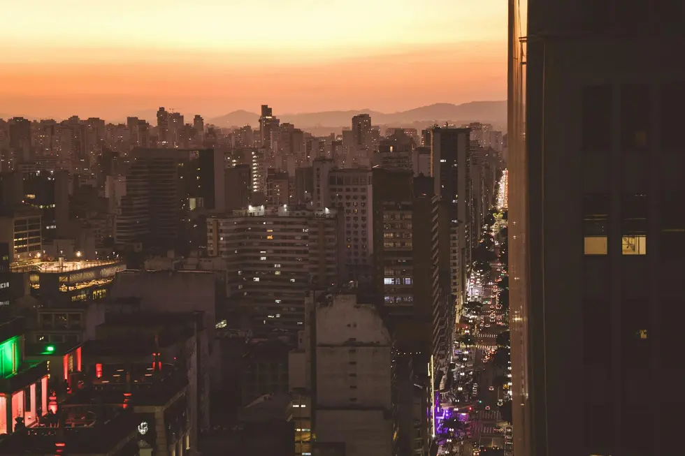 Casas iluminadas com energia e painéis solares ao fundo da cidade