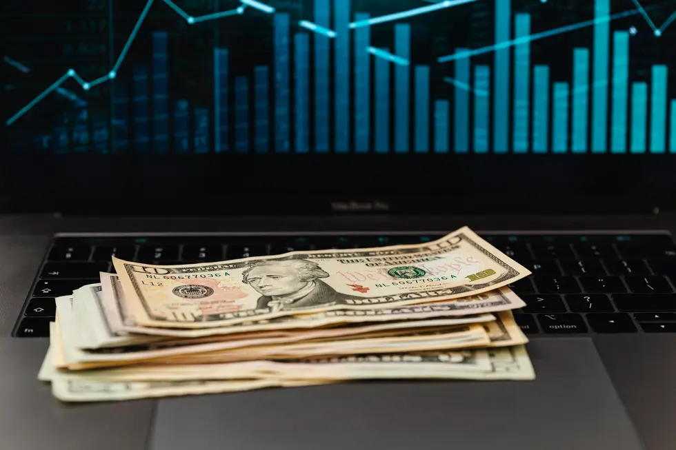 Notebook com gráficos de IPO ao lado de dinheiro e objetos de casa
