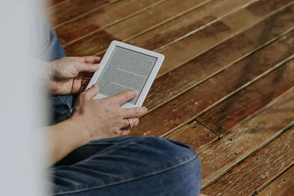 Kindle em mesa com livros e café em casa brasileira