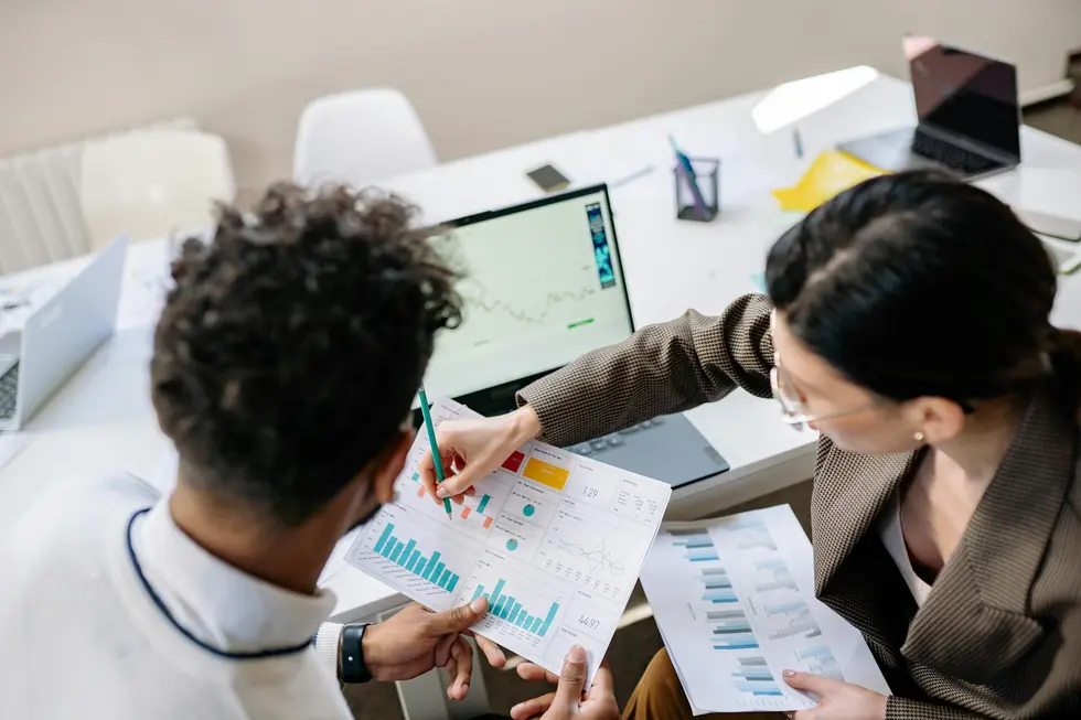 Casal olhando gráficos de market data no notebook em casa