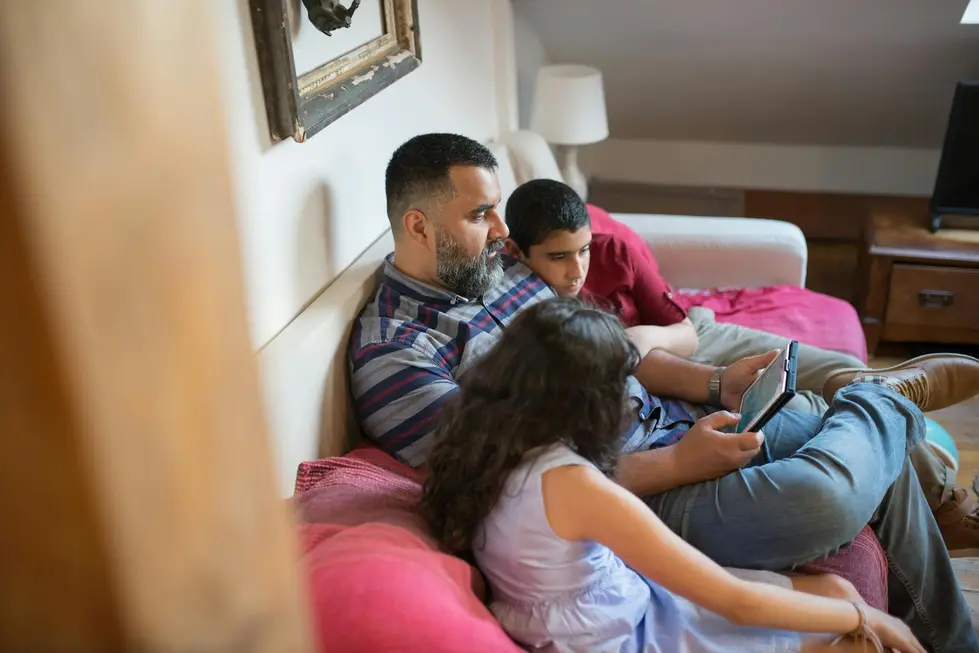Família reunida olhando tablet com comparativos de preços