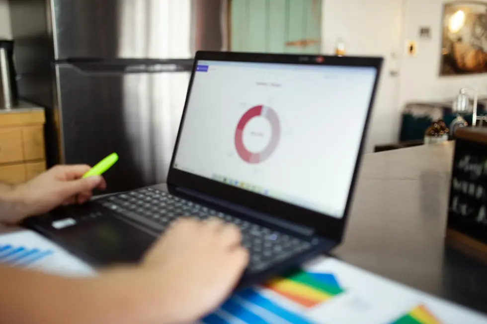 Notebook exibindo gráficos financeiros em home office familiar